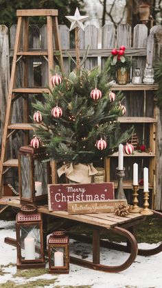 a christmas tree sitting on top of a wooden bench next to a ladder and other decorations