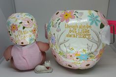 there is a small doll next to a decorative egg