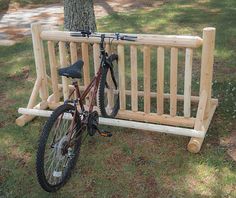 a bike leaning against a wooden bench in the grass