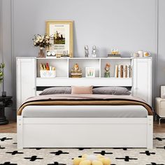 a white bed sitting next to a book shelf on top of a dresser in a bedroom