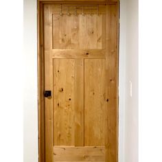 a wooden door in a white room