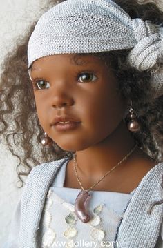 a close up of a doll wearing a headband