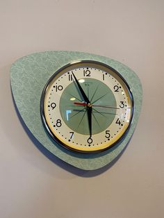 a clock that is on the side of a wall with two hands and an hour