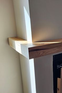 the corner of a room with a wooden shelf