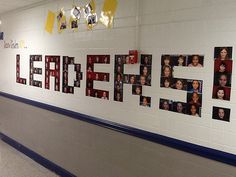 a hallway with several pictures on the wall and hanging from the ceiling, along with lights