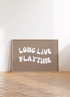 a long live playtime sign sitting on top of a hard wood floor next to a white wall