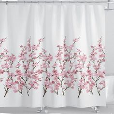 a white shower curtain with pink flowers on it