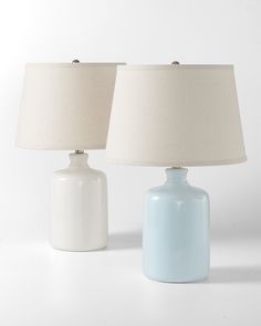 two blue and white lamps sitting next to each other