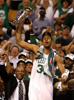 a man holding up a trophy in front of a crowd