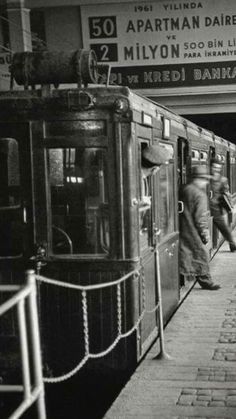 an old black and white photo of people getting on the train at a subway station