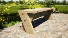 a wooden bench sitting on top of a brick walkway next to green grass and trees