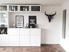 a living room with white furniture and wooden floors