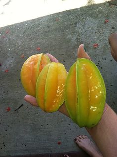 two pieces of fruit sitting on top of a person's hand next to each other