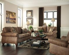 a man sitting in a living room next to two couches