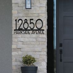 a black and white sign that reads 1260 parkside avenue next to a potted plant