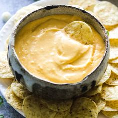 a white plate topped with tortilla chips and dip