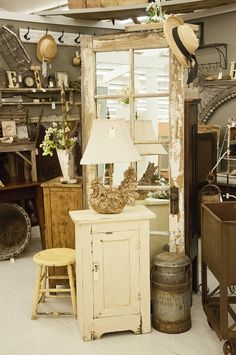 a room filled with lots of old furniture and decor on top of each other in front of a window