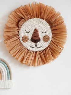 a wall hanging with a lion face on it next to a rainbow rug and a wooden clock