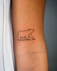 a small bear tattoo on the arm