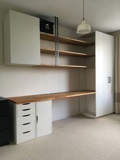 an empty room with some shelves and drawers