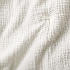 an unmade bed with white sheets and pillows