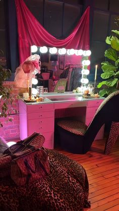 a leopard print chair sits in front of a vanity with lights on and a mirror