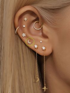 a woman wearing ear piercings with stars and moon designs