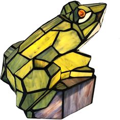 a stained glass lamp that looks like a lizard on top of a block of wood