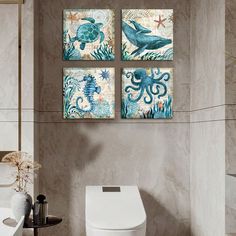 three paintings on the wall above a toilet in a bathroom