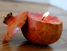 two pomegranate halves with a candle in the middle