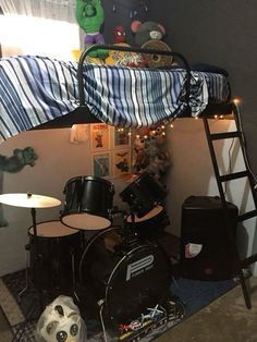 a bedroom with a bunk bed next to a drum set and a stuffed animal on the floor