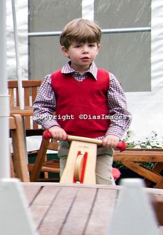 a young boy riding a wooden toy car