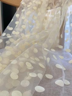 white polka dot sheer fabric on top of a bed