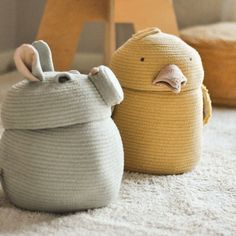 two knitted animals sitting next to each other on the floor in front of a chair