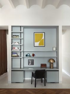 a modern home office with built - in shelving units and shelves, along with a painting on the wall