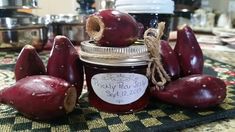 a jar filled with red fruit sitting on top of a table next to other items