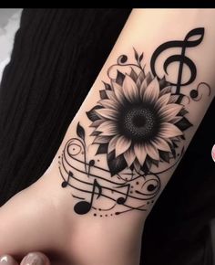 a sunflower with music notes on it's wrist and foot tattoo design for women