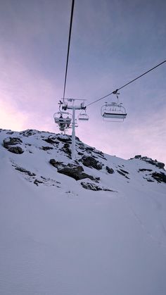 a ski lift going up the side of a snow covered mountain