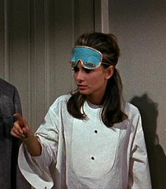 a man and woman wearing blindfolds standing next to each other in front of a door