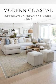 a living room with white couches and pillows on top of a rug in front of a large window