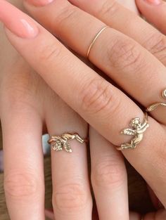 a woman's hand with three rings on it and one is holding the other