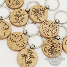 wooden key chains with flowers and leaves engraved on them