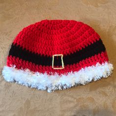 a crocheted santa hat with white and black stripes on it sitting on a table