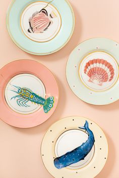 three plates with different designs on them and one has a blue fish in the middle