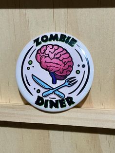 a white plate with a knife and fork in it that says zombie dinner on it