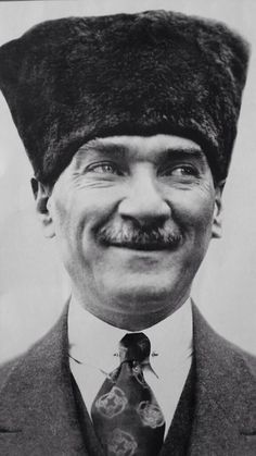 an old black and white photo of a man with a hat on top of his head