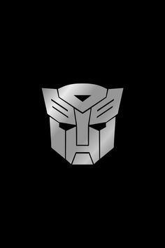 a black and white image of a transformer head on a dark background with the word,