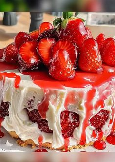 there is a cake with strawberries on top and icing drizzled over it