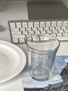 a clear glass sitting on top of a table next to a computer keyboard and mouse