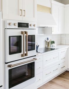 a kitchen with white cabinets and gold trim on the oven, stove top and microwave